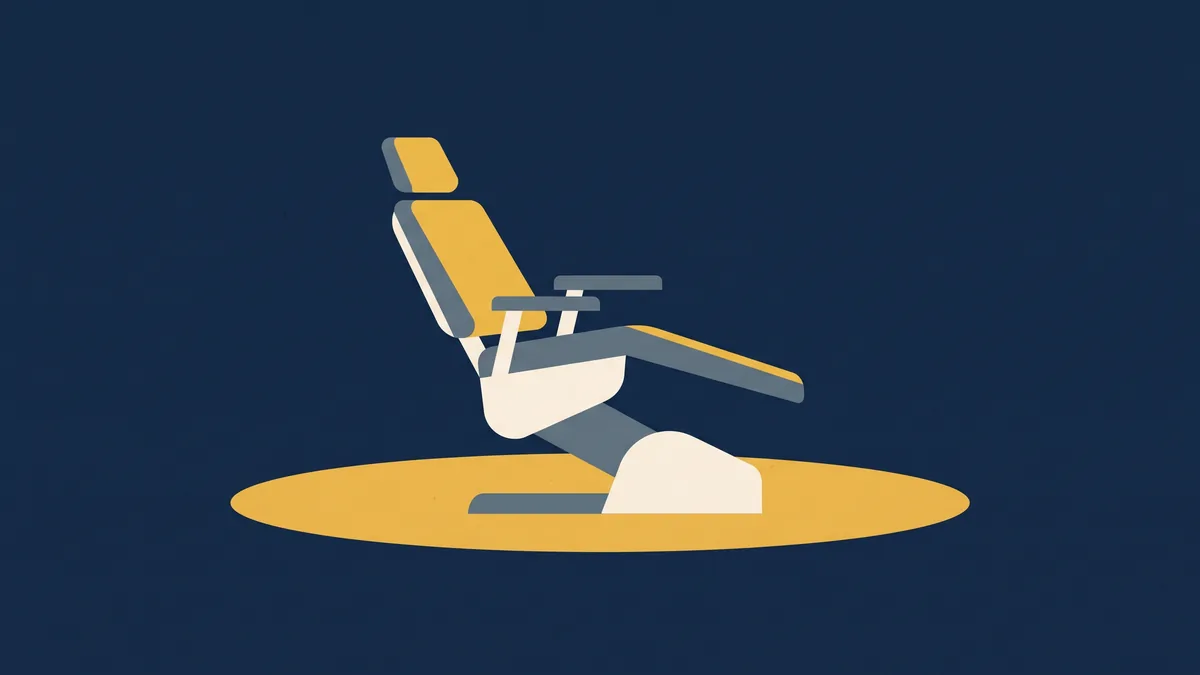 An empty dental chair standing in a pool of light